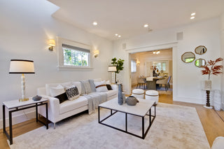 Modern living room with white sofa, coffee table, and decorative items.