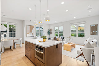 Modern kitchen and living room with white walls and wooden flooring