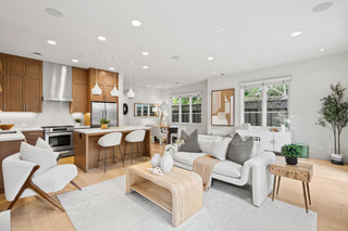 Modern living room and kitchen with white furniture and wooden accents