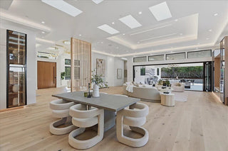 Modern living room with a stylish dining table and chairs in a well-lit space.