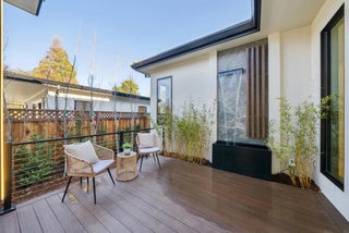 Modern outdoor deck with chairs, table, and wonderful water feature 