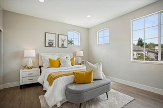 Modern room_featuring_a_white_and_mustard_yellow_bed_grey_wall_art_depicting_a_raccoon_and_a_rabbit.