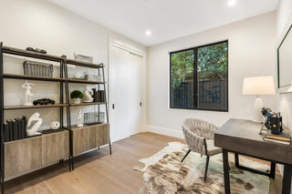 Modern home office with bookshelf, desk, and chair.