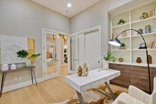 Modern home office with a desk, bookshelf, and decorative items.