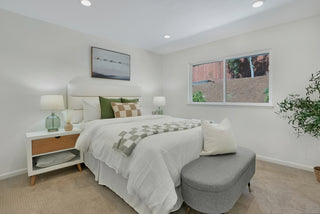 Neatly arranged bedroom with a bed, nightstands, and decor.