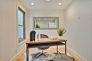 Home office with a desk, chair, and decorative items in a well-lit room.
