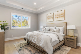 Modern bedroom with a bed, nightstands, and wall art.