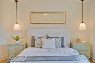 Neatly made bed with decorative pillows in a bedroom setting.