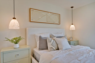 Neatly made bed with decorative pillows in a bedroom setting.
