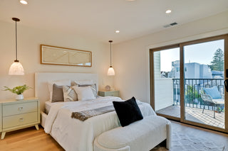 Modern bedroom with a bed, nightstands, and a sliding glass door leading to a balcony.