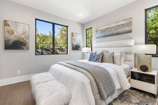 Modern bedroom with a bed, nightstands, and abstract art on the walls.