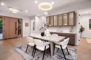 Sleek dining room with a table and chairs in a well-lit home interior.