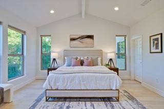 Spacious bedroom with a large bed, side tables, and large windows.
