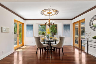 Spacious living room with large windows, wooden floors, and a cozy beige sofa. Blue rug and rustic coffee table enhance the modern, serenes decors.