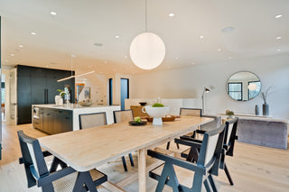 Modern kitchen and dining area with a wooden table and chairs.