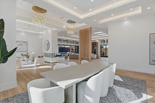 Modern living room with a dining table and chairs, featuring a TV and decorative elements.