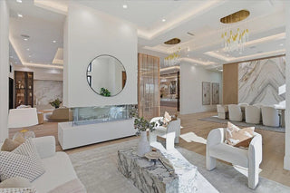 Modern living room with white furniture, marble fireplace, and decorative elements.