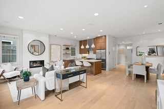 Modern living room and kitchen with white walls and wooden flooring