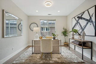 Modern home office with desk, chair, and decorative elements.