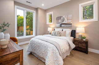 Neatly arranged bedroom with a bed, nightstands, and wall art.
