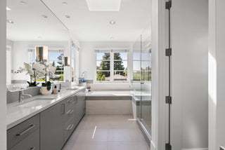 Modern bathroom with gray cabinets, white countertop, and large mirror.