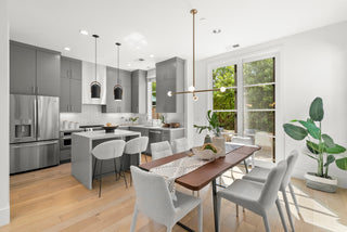 stunning  kitchen with stainless steel appliances, wooden dining table, and white chairs 
