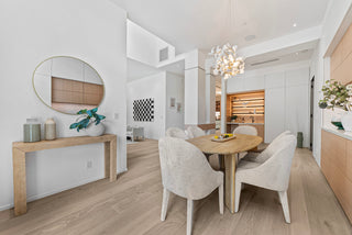 Modern dining room with wooden table and chairs, light-colored walls, and a console table.