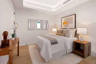 updated bedroom with a bed, nightstands, and decorative items.